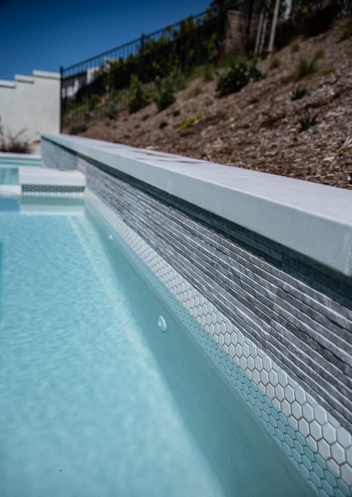 Cette image montre un petit piscine avec aménagement paysager arrière minimaliste sur mesure avec une terrasse en bois.