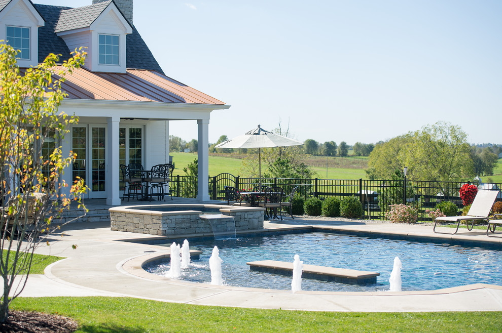 Example of a large transitional backyard concrete and rectangular pool house design in Other
