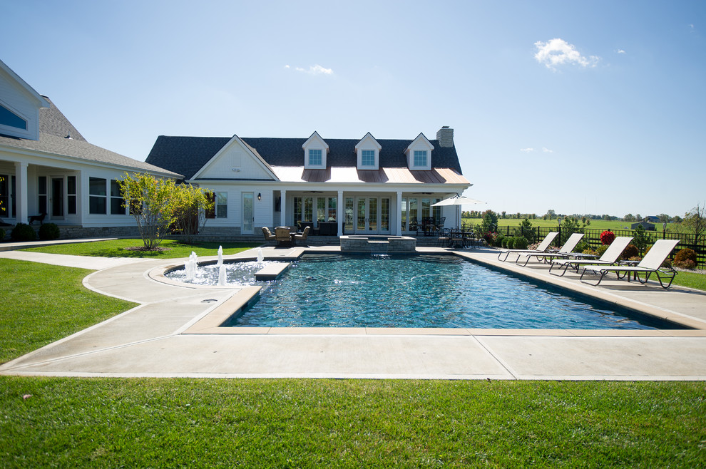 Стильный дизайн: большой прямоугольный бассейн на заднем дворе в стиле неоклассика (современная классика) с домиком у бассейна и покрытием из бетонных плит - последний тренд