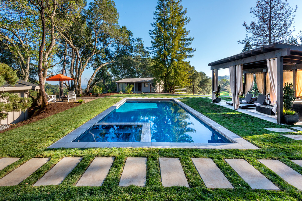 Idee per una piscina monocorsia moderna rettangolare di medie dimensioni e dietro casa con una vasca idromassaggio e lastre di cemento