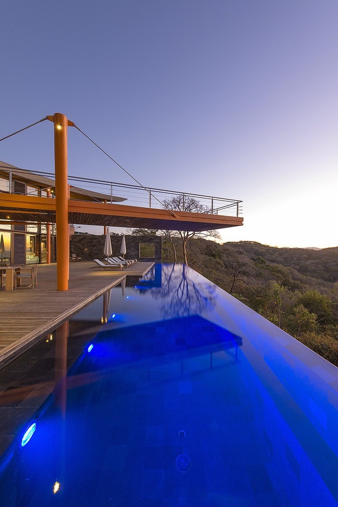 Expansive contemporary back rectangular infinity swimming pool in New York with decking.