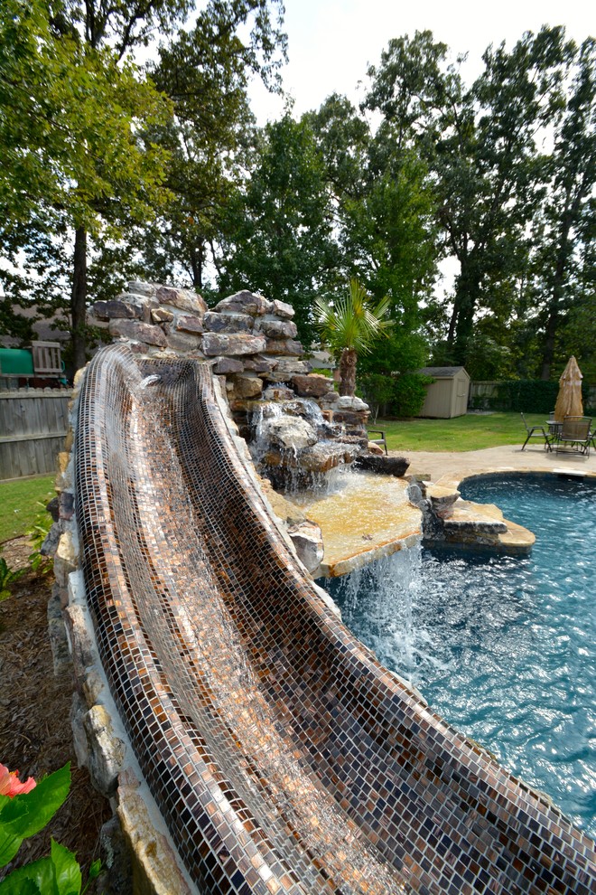 Пример оригинального дизайна: спортивный бассейн произвольной формы, среднего размера на заднем дворе в стиле рустика с водной горкой и покрытием из каменной брусчатки