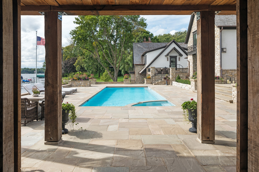 На фото: бассейн на заднем дворе в классическом стиле с покрытием из каменной брусчатки с
