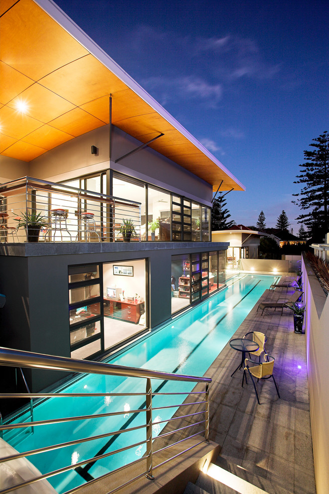 Esempio di una piscina monocorsia contemporanea rettangolare dietro casa con pavimentazioni in cemento