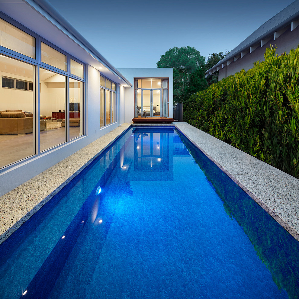 Esempio di una piscina monocorsia moderna rettangolare in cortile con lastre di cemento