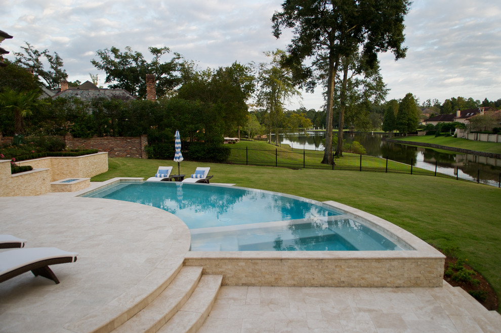 Esempio di una piccola piscina a sfioro infinito design personalizzata dietro casa con una dépendance a bordo piscina e pavimentazioni in cemento