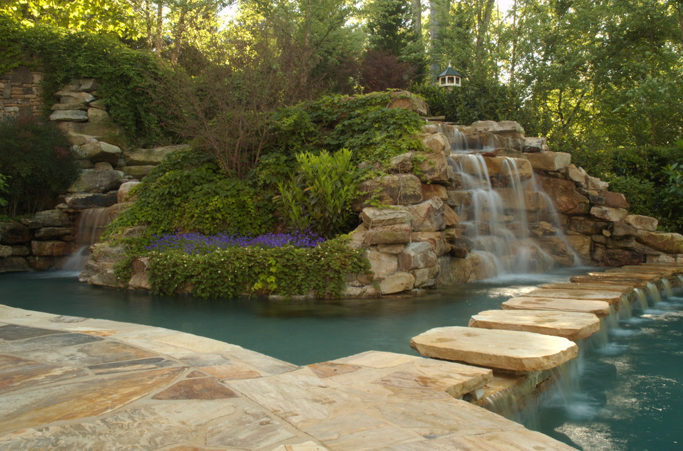 Foto de piscina con fuente infinita tradicional extra grande a medida en patio trasero con adoquines de piedra natural