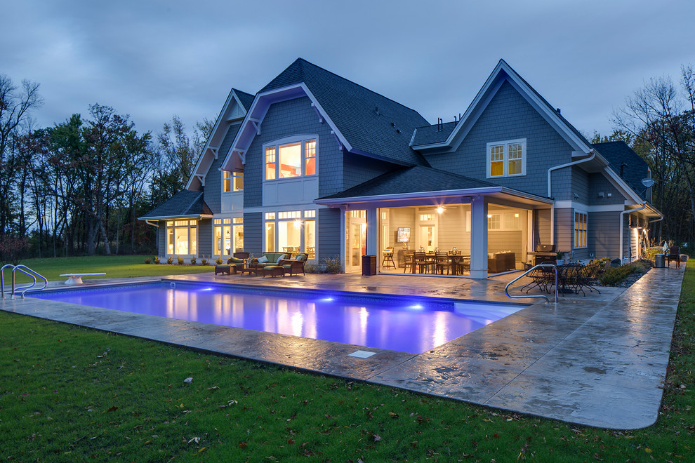 Стильный дизайн: большой прямоугольный бассейн на заднем дворе в стиле неоклассика (современная классика) с покрытием из декоративного бетона - последний тренд