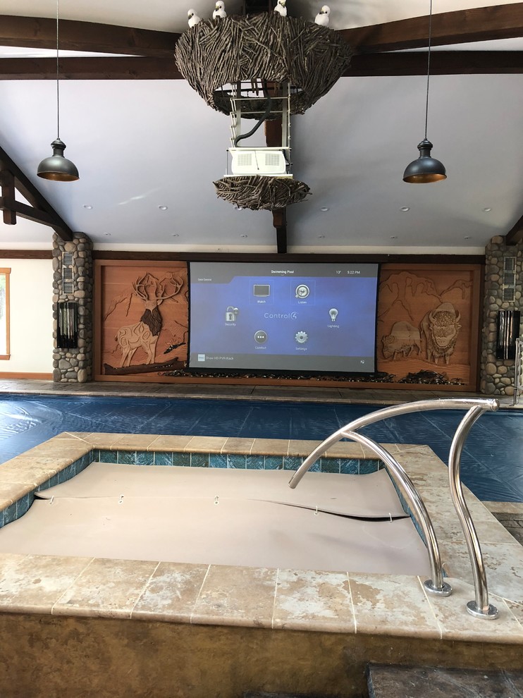 Immagine di un'ampia piscina coperta naturale eclettica rettangolare con una dépendance a bordo piscina e cemento stampato