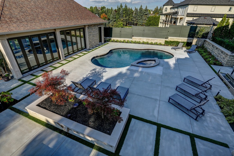 Идея дизайна: бассейн среднего размера, в форме фасоли на заднем дворе в стиле неоклассика (современная классика) с домиком у бассейна и покрытием из бетонных плит