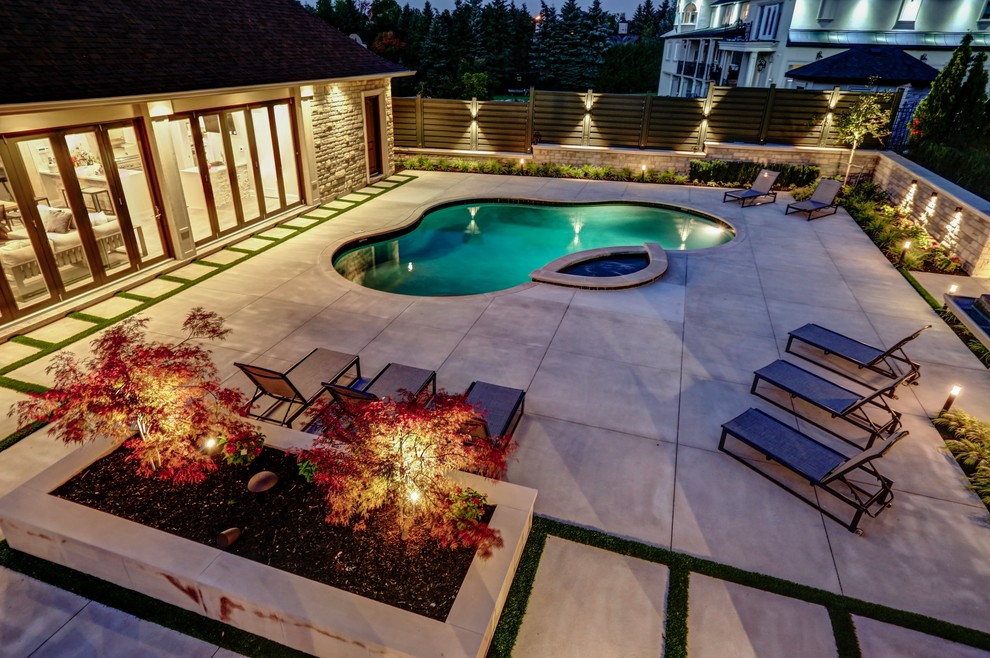 Diseño de casa de la piscina y piscina tradicional renovada de tamaño medio tipo riñón en patio trasero con losas de hormigón