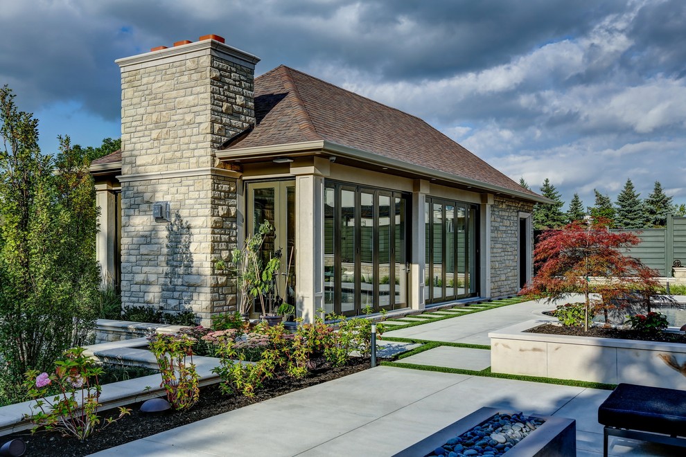 Foto de casa de la piscina y piscina tradicional renovada de tamaño medio tipo riñón en patio trasero con losas de hormigón