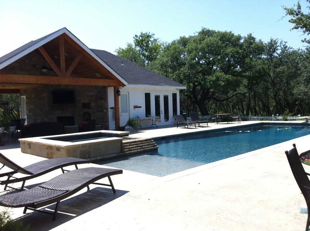 Foto di un'ampia piscina monocorsia country rettangolare dietro casa con una dépendance a bordo piscina e pavimentazioni in pietra naturale