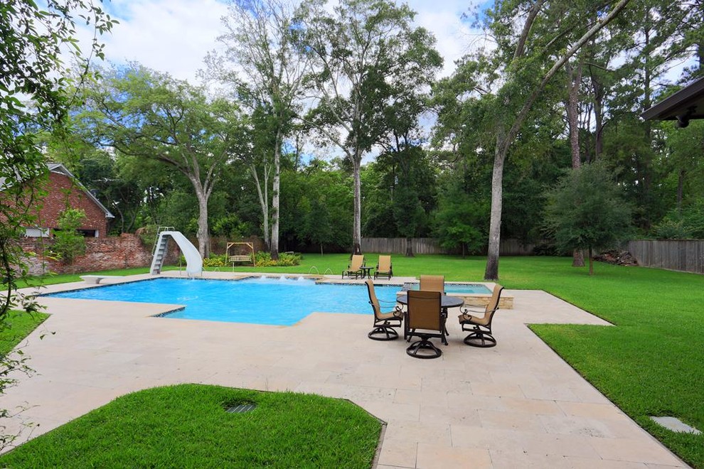 Diseño de piscina con fuente elevada tradicional grande a medida en patio trasero con suelo de baldosas