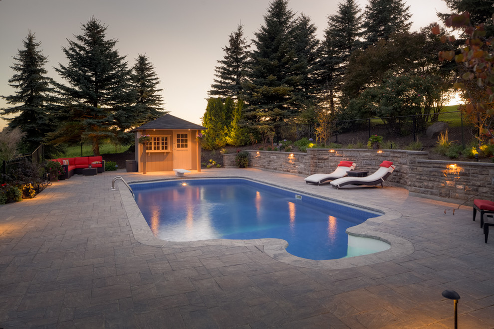 Стильный дизайн: большой бассейн произвольной формы на заднем дворе в стиле неоклассика (современная классика) с мощением тротуарной плиткой - последний тренд
