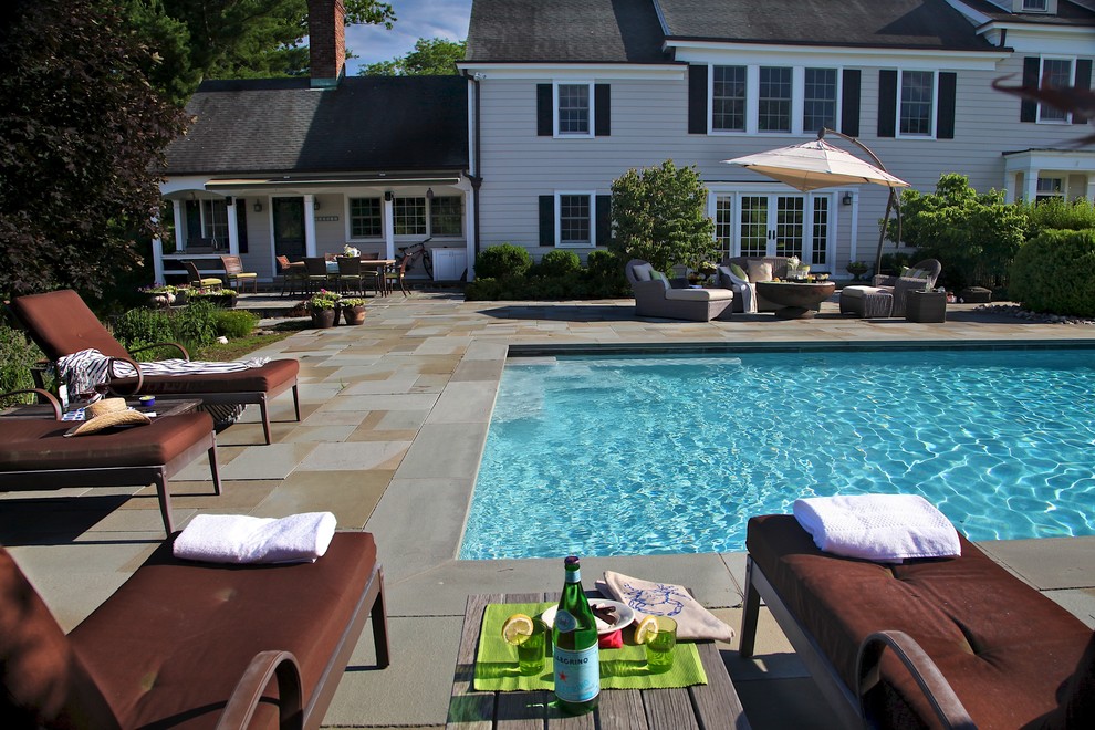 Example of a mid-sized classic backyard stone and rectangular lap hot tub design in New York