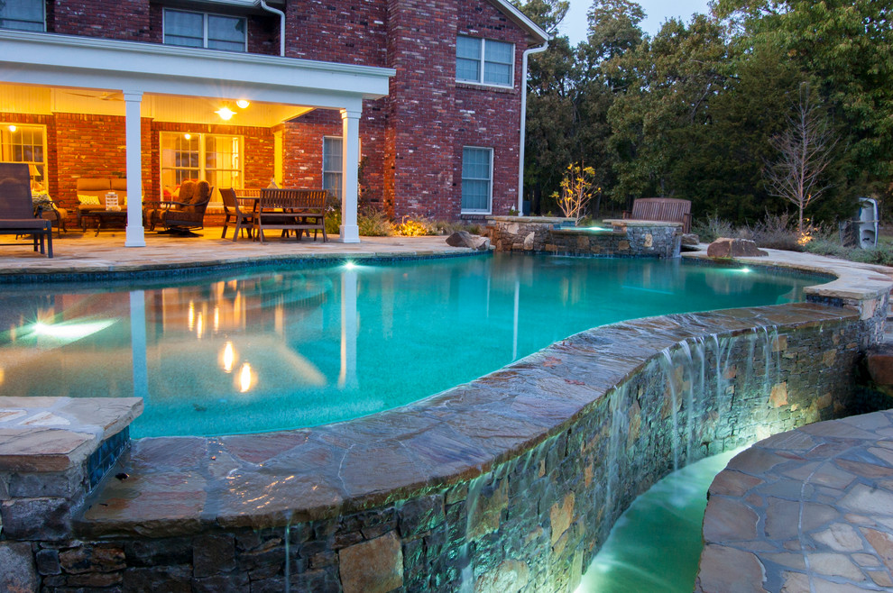 Diseño de piscinas y jacuzzis de estilo de casa de campo de tamaño medio a medida en patio trasero con adoquines de piedra natural