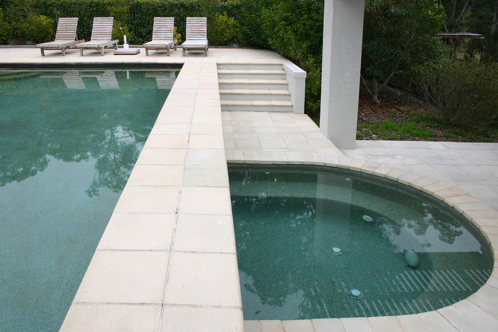 Foto de piscina alargada tradicional extra grande rectangular en patio trasero con adoquines de hormigón