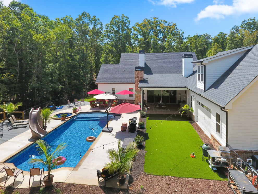 Diseño de piscinas y jacuzzis de estilo de casa de campo de tamaño medio rectangulares en patio trasero con losas de hormigón
