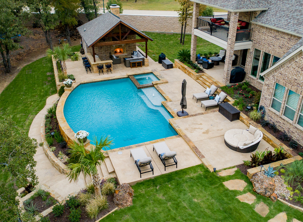 Diseño de piscinas y jacuzzis de estilo de casa de campo grandes a medida en patio trasero con suelo de hormigón estampado
