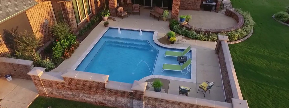 Modelo de piscina con fuente clásica renovada a medida en patio con suelo de hormigón estampado