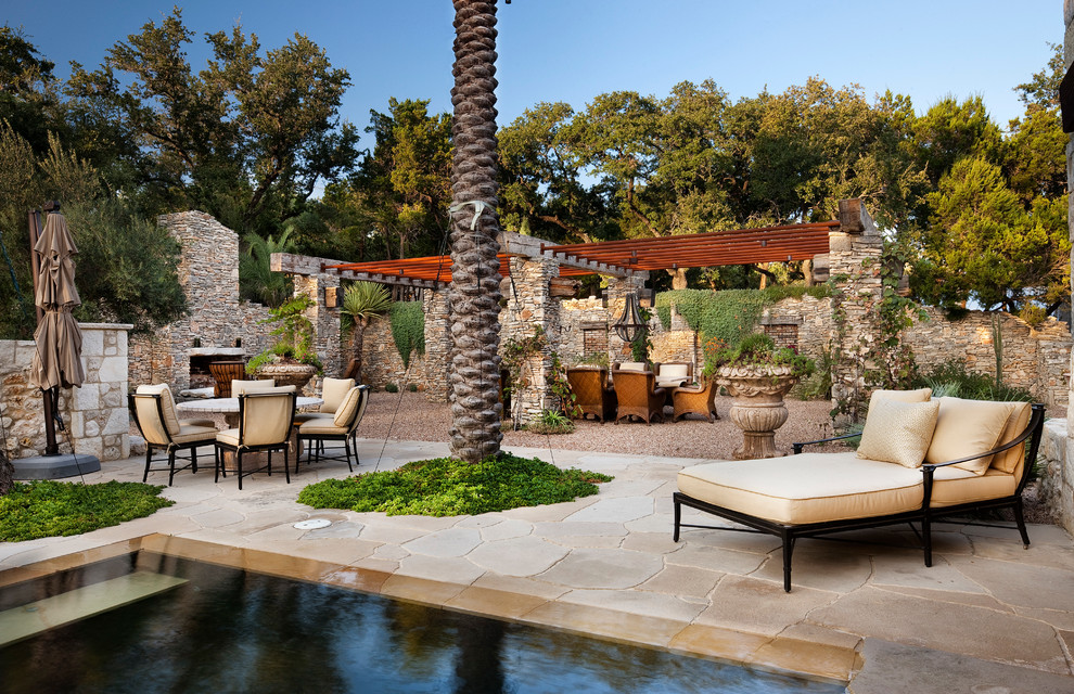 Diseño de piscina infinita mediterránea extra grande a medida en patio trasero con adoquines de piedra natural