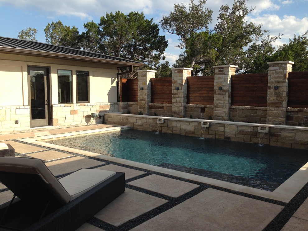 Design ideas for a large contemporary courtyard rectangular swimming pool in Austin with a water feature and concrete paving.