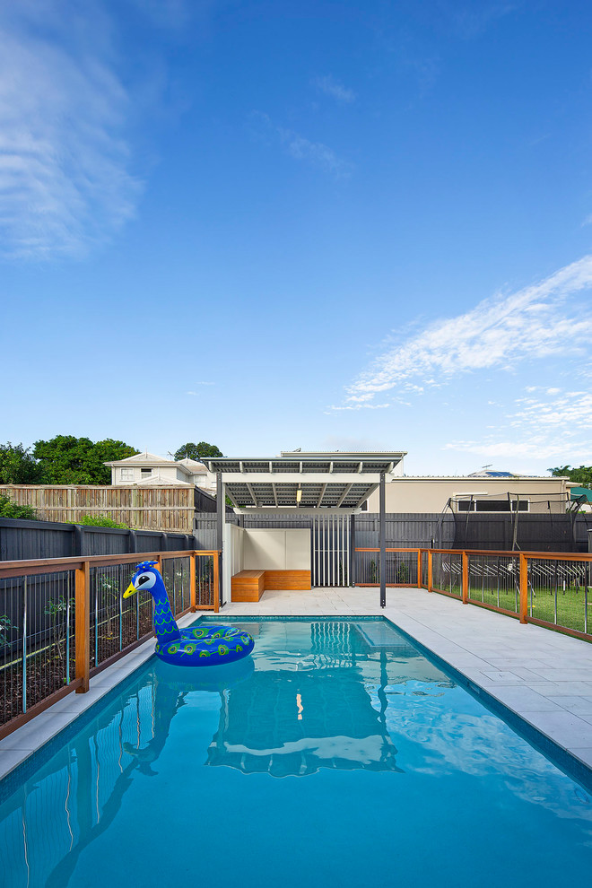 Imagen de piscina marinera de tamaño medio rectangular en patio trasero con adoquines de piedra natural