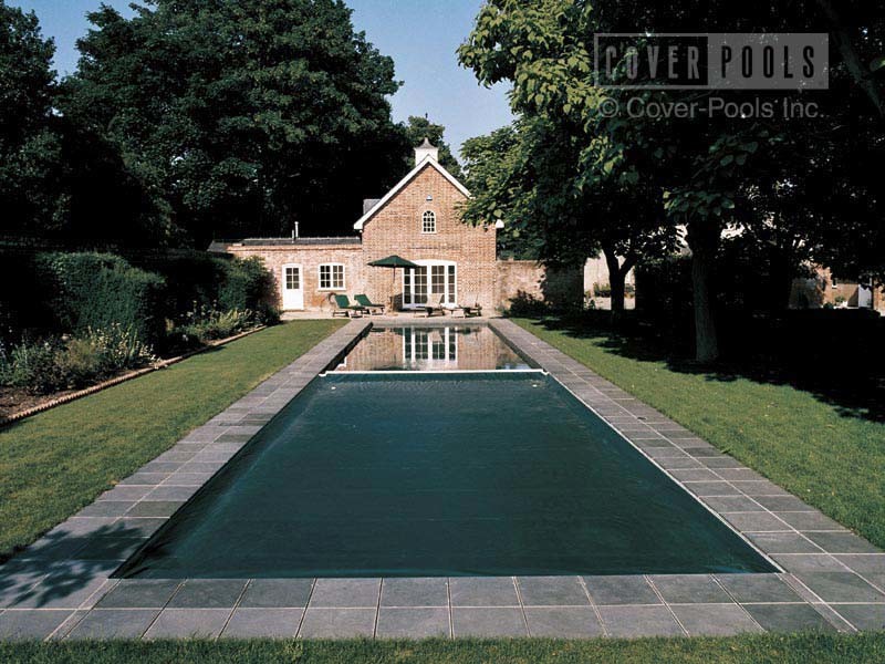 This is an example of a large traditional back rectangular lengths swimming pool in New York with natural stone paving.
