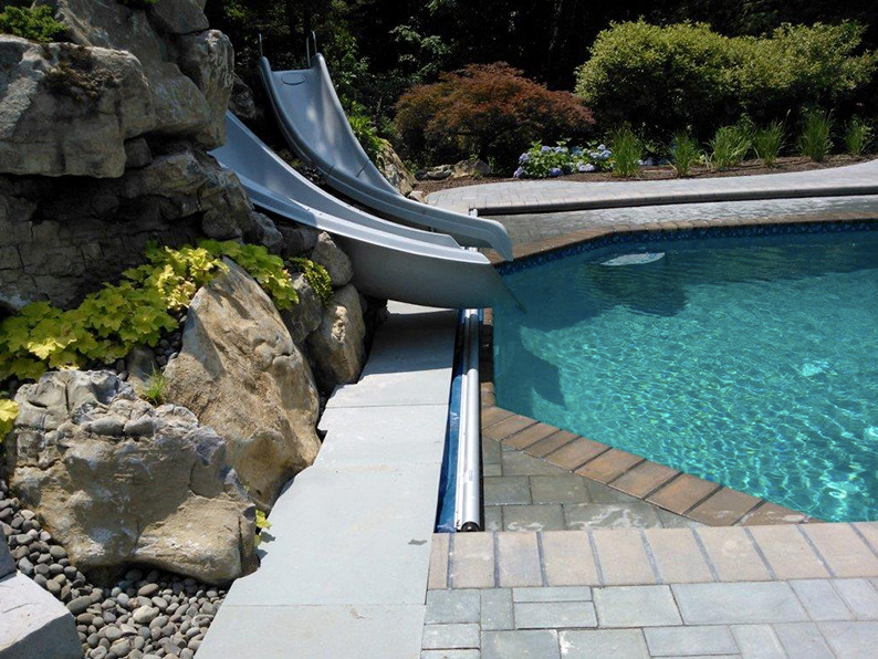 Идея дизайна: спортивный бассейн среднего размера, произвольной формы на заднем дворе в классическом стиле с водной горкой и покрытием из каменной брусчатки