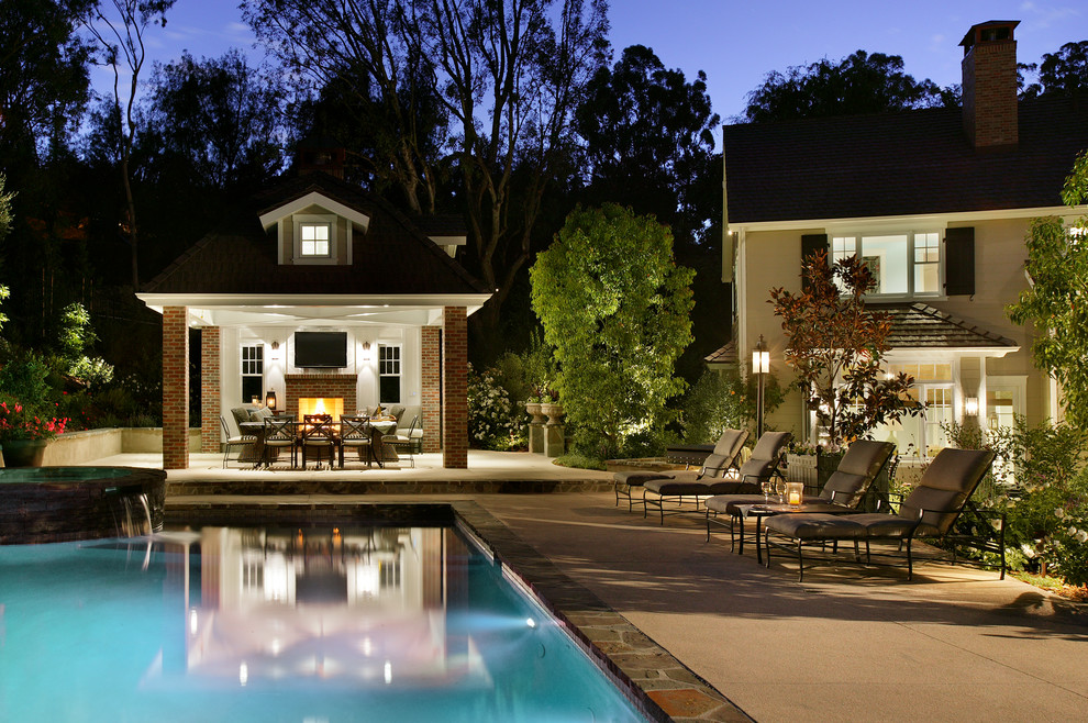 На фото: прямоугольный бассейн среднего размера на заднем дворе в стиле кантри с домиком у бассейна и покрытием из каменной брусчатки