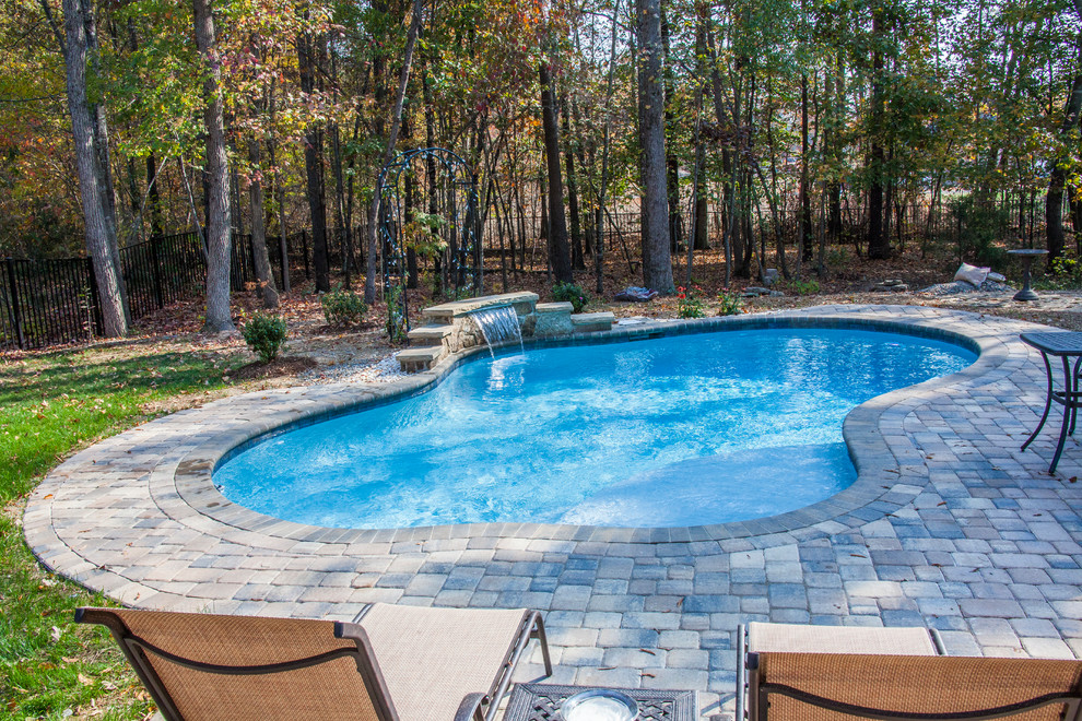 Cette image montre une piscine naturelle et arrière design de taille moyenne et sur mesure avec une terrasse en bois.