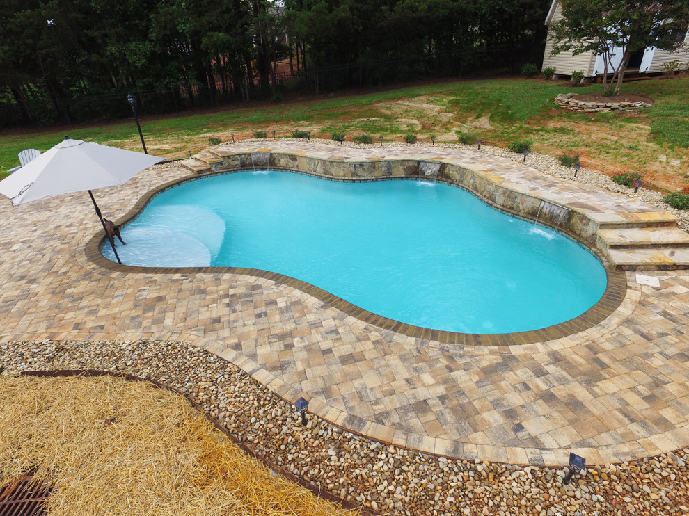 Aménagement d'une piscine naturelle et arrière contemporaine de taille moyenne et sur mesure avec une terrasse en bois.