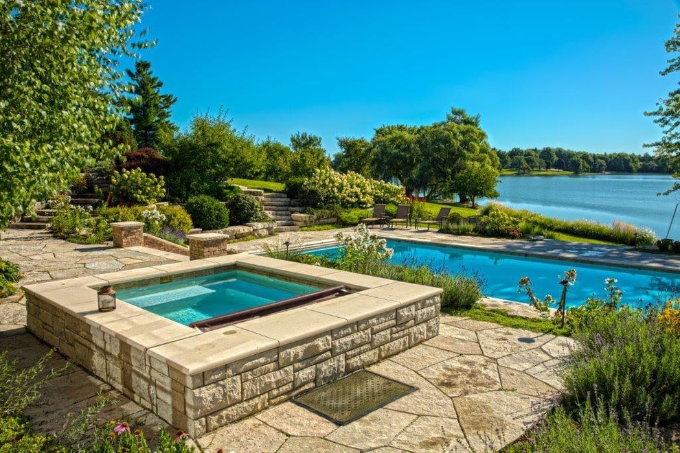 Idée de décoration pour une piscine naturelle et arrière craftsman de taille moyenne et rectangle avec un bain bouillonnant et des pavés en pierre naturelle.