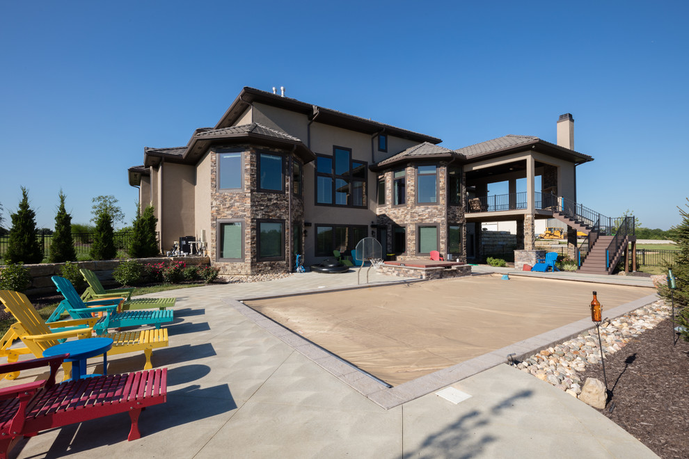 Ejemplo de piscinas y jacuzzis de estilo americano de tamaño medio rectangulares en patio trasero con losas de hormigón