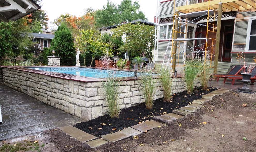 Foto di una piscina fuori terra tradizionale rettangolare di medie dimensioni e dietro casa con pavimentazioni in cemento