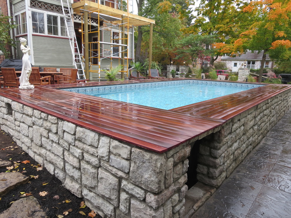 Foto di una piscina fuori terra classica rettangolare di medie dimensioni e dietro casa con pavimentazioni in cemento