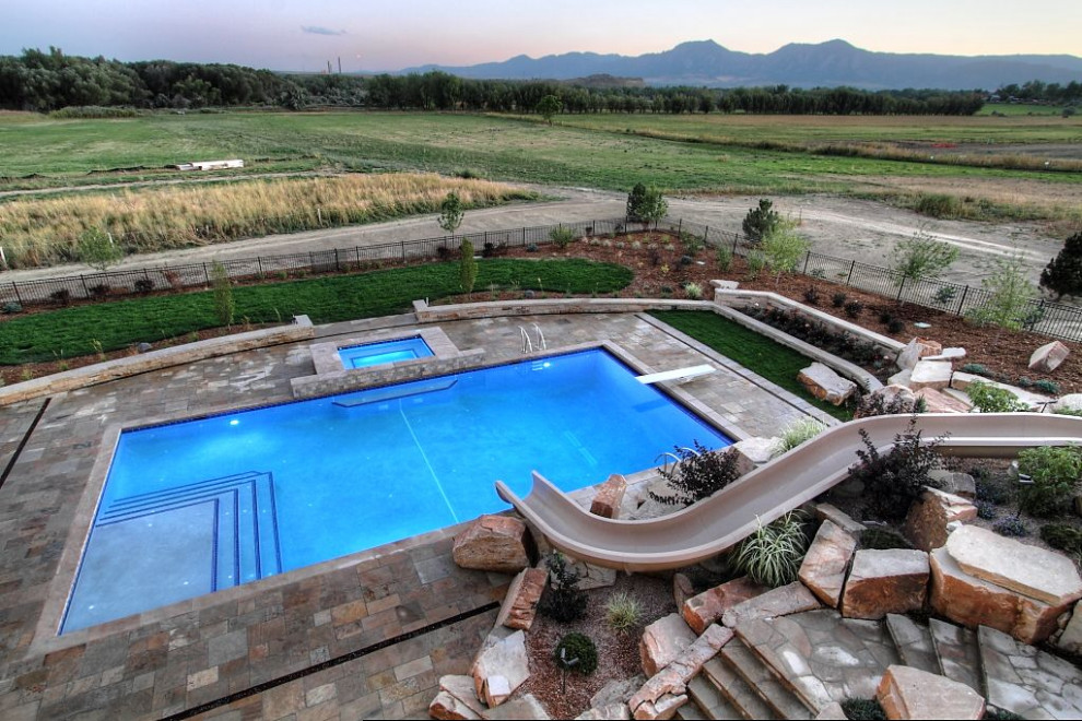 Inspiration för en stor rektangulär pool på baksidan av huset, med vattenrutschkana