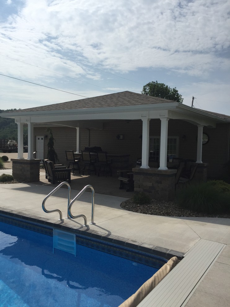 На фото: спортивный, прямоугольный бассейн среднего размера на заднем дворе в стиле кантри с домиком у бассейна и покрытием из декоративного бетона
