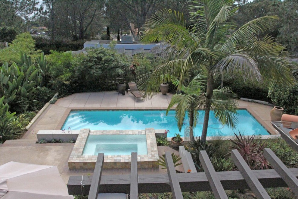 Imagen de piscinas y jacuzzis naturales mediterráneos de tamaño medio rectangulares en patio trasero con losas de hormigón