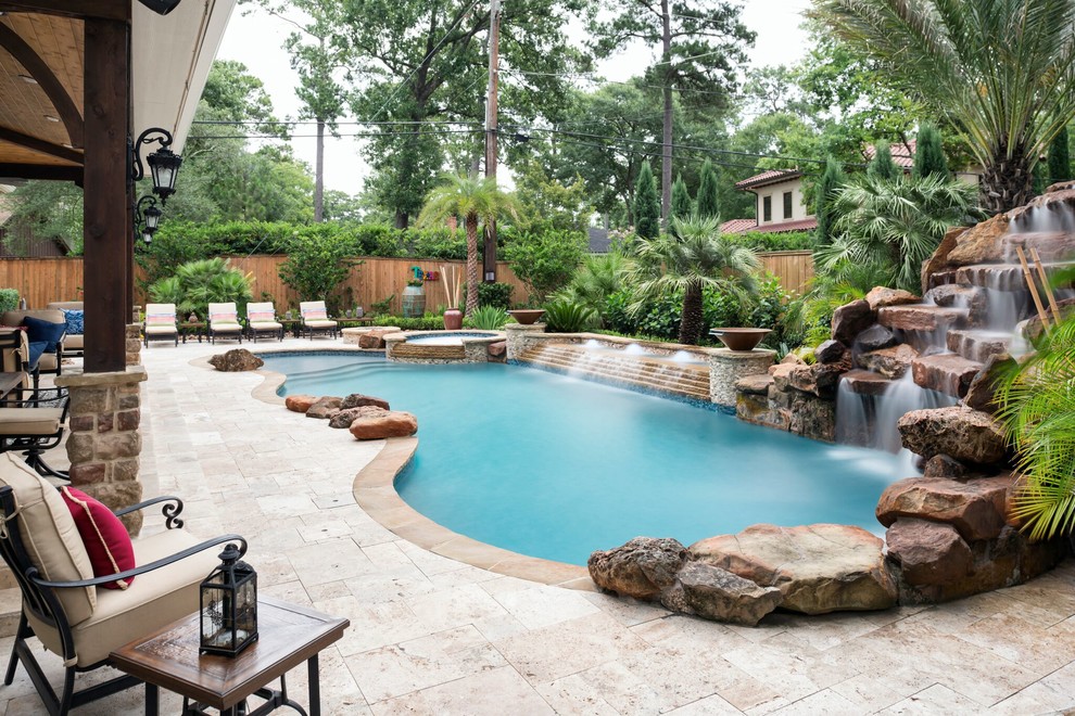 Hot tub - tropical backyard tile and custom-shaped hot tub idea in Houston