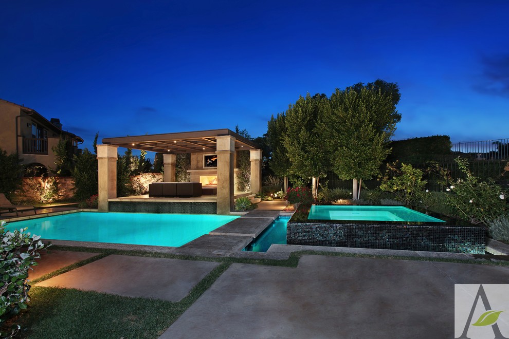Источник вдохновения для домашнего уюта: большой естественный, прямоугольный бассейн на заднем дворе в средиземноморском стиле с джакузи и покрытием из каменной брусчатки