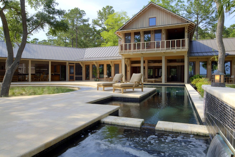 This is an example of a large contemporary back custom shaped hot tub in Atlanta with natural stone paving.