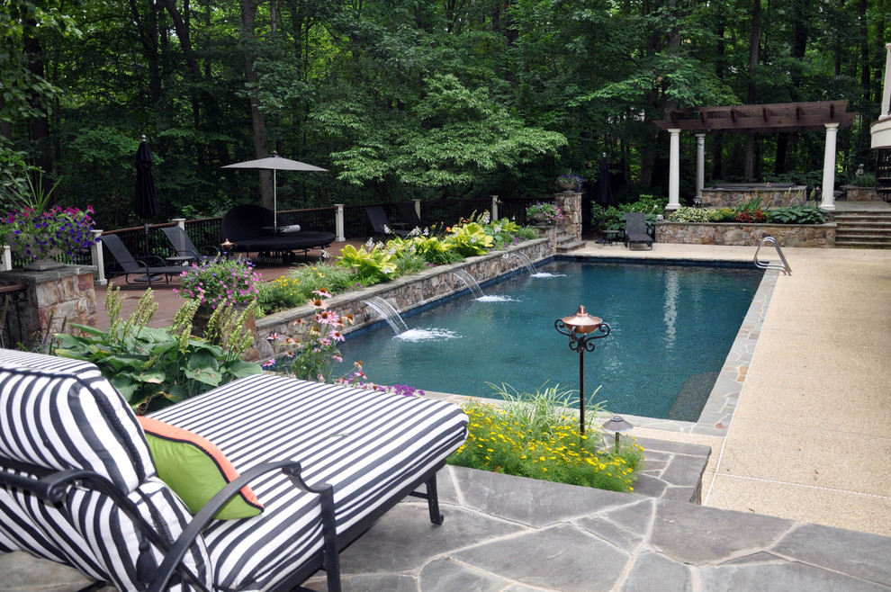 Imagen de piscina con fuente alargada de estilo americano extra grande rectangular en patio trasero con adoquines de piedra natural