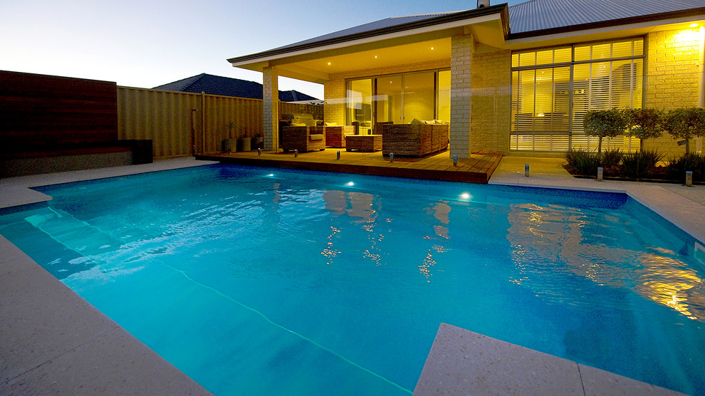 Esempio di una piscina monocorsia etnica rettangolare di medie dimensioni e dietro casa con pavimentazioni in cemento