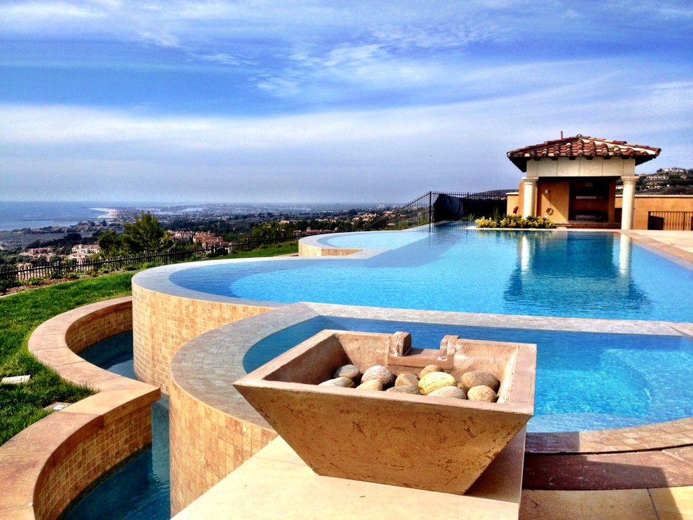Idée de décoration pour une grande piscine à débordement et arrière méditerranéenne sur mesure avec du carrelage et un bain bouillonnant.
