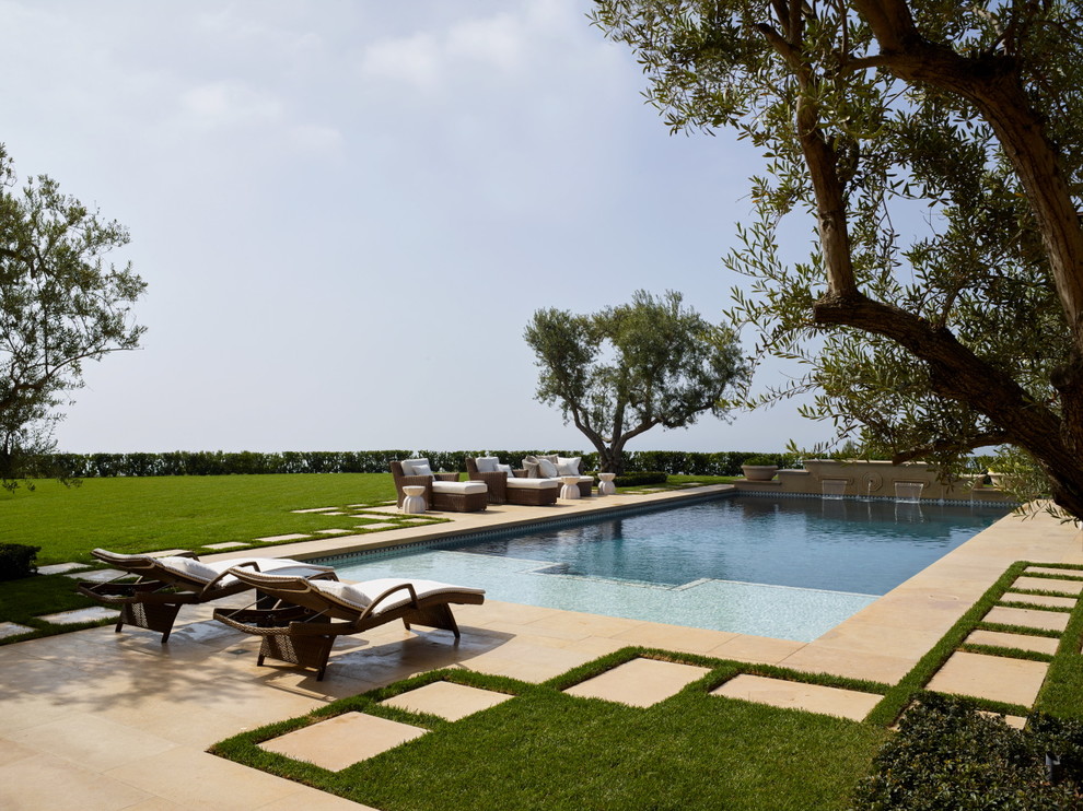 Imagen de casa de la piscina y piscina alargada mediterránea grande rectangular en patio trasero con adoquines de hormigón