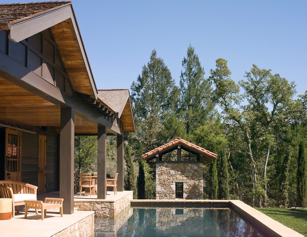 Diseño de piscina elevada rural de tamaño medio a medida en patio trasero con adoquines de piedra natural