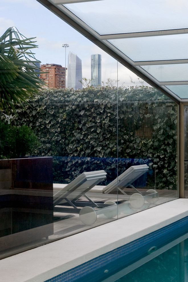Immagine di una piscina coperta moderna di medie dimensioni con una dépendance a bordo piscina