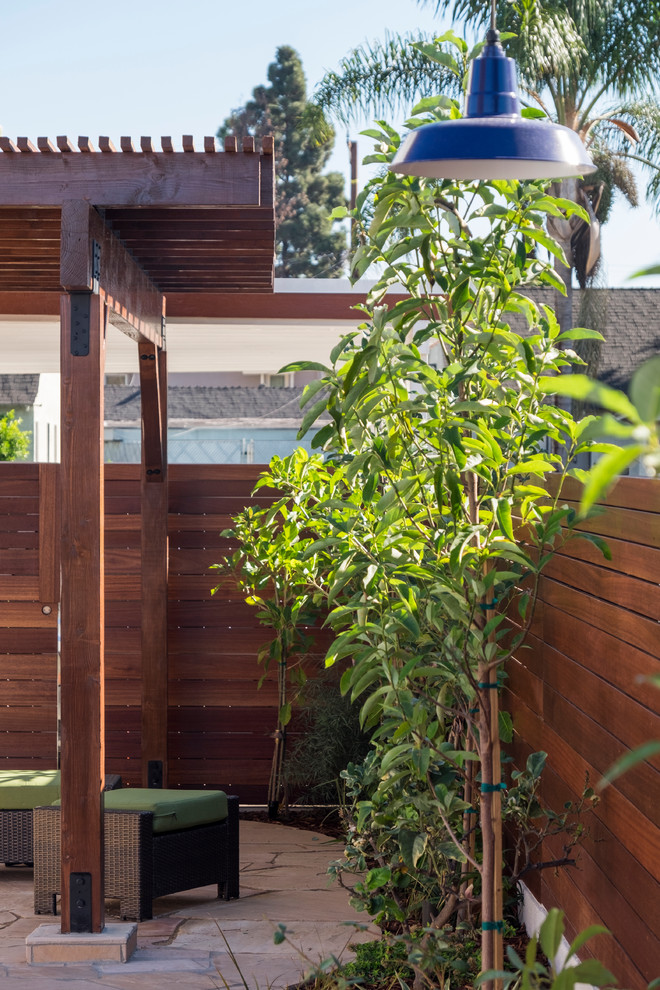 Идея дизайна: солнечный, весенний засухоустойчивый сад среднего размера на заднем дворе в средиземноморском стиле с покрытием из каменной брусчатки, высокими грядками, хорошей освещенностью и с деревянным забором